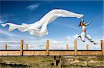 Young beautiful woman jumping with a scarf in a beautiful day