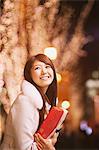 Young Women Holding Christmas Gift And Smiling