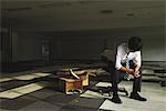 Businessman Sitting On Chair At Deserted Office