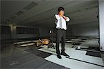 Businessman Standing At Deserted Office Head On Hands