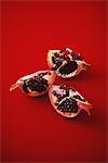 Slices Of Pomegranate On Red Background