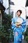 Young Japanese Woman walking In Street Wearing Yukata