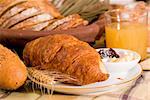 Rustic various baked bread with orange juice