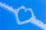 A heart shaped cloud formation against a blue sky.