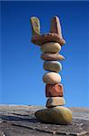 Column of balanced boulders against blue sky