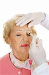 Senior woman getting cosmetic injections to remove forehead wrinkles.  White background.