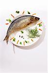herring on the white plate with black pepper and carrot