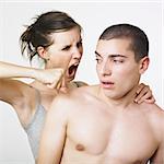 Angry girlfriend ready to punch guy with clenched fist . White background.
