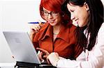 two beautiful women are working at laptop