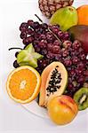 Healthy fruit assortment with papaya, kiwi, orange and grapes