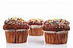 Three tasty muffins with chocolate, isolated on white background. Shallow DOF