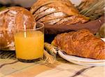 Rustic various baked bread with orange juice