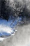 A winter landscape showing a foggy river on a cold day