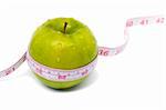 Green apple with measuring tape and water drops. Weight loss series.