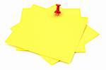 three yellow sticky notes thumbtacked to white background, focus is set on thumbtack