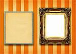 hollow gilded picture frame and empty pinboard against striped wall