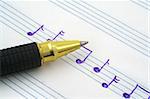 close-up of hand written music note and ballpoint pen tip