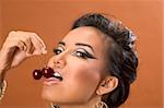 Young woman licking ripe red sweet cherries