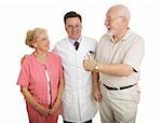 Senior couple giving a thumbs-up to their eye doctor after a successful office visit.  Isolated on white.