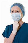 Close up of a woman surgeon doctor wearing protective hair net and face mask and latex examination gloves