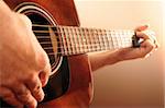 Hands of a person playing an acoustic guitar