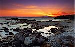 Image shows a spectacular sunset over a rocky seascape, in Mani peninsula, southern Greece