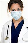 Brunette lady doctor wearing white lab coat with a stethoscope around shoulders and a blue mask over face