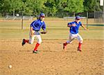 Two Boys in Uniform Running for the Ball