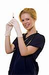Young pretty blond woman healthcare worker wearing blue scrubs and a stethoscope holding up a syringe or needle wearing latex gloves standing on white