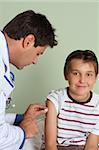 A doctor gives a child a vaccine or flu shot in the arm.