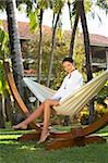 Woman relaxing on hammock at exotic surrounding at bali indonesia