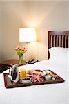 Breakfast tray laying on white bed in upscale hotel.