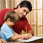Hispanic father helping son with homework.