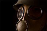 Person in gas mask on black background