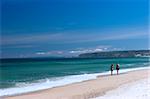 Couple walking on the white sand in a beautiful beach