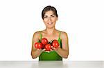 Beautiful young woman in the kitchen holding tomatos on her hands