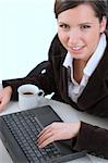 Young smiling woman working with a computer in an office