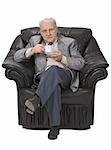 Senior man enjoying a cup of tea in his office armchair.