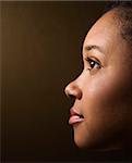 Close-up profile portrait of serious African-American young adult female.