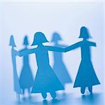 Paper cutout girls holding hands standing in circle.