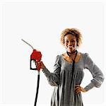 Woman holding gasoline pump nozzle smiling.