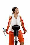 Young woman training on exercise bike at the gym whit a bottle of water on the left hand
