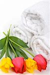 Elegant colorful tulips and soft cotton towels in a spa