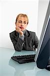 Caucasian woman looking bored at computer.