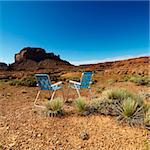 Two lawn chairs in scenic desert landscape with butte landformation.