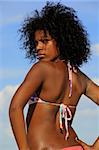 Young model wearing bikini against tropical sky