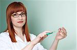 red-haired doctor in white smock filling the syringe. lot of copyspace.