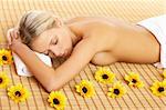 Portrait of Beautiful woman laying on bamboo mat around yellow flowers