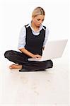 Businesswoman working on her laptop while sitting on the floor