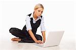 Businesswoman working on her laptop while sitting on the floor